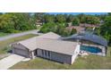 An aerial view showcasing a well-maintained home with a screened-in pool and lush green surroundings at 1420 Felton St, Deltona, FL 32725