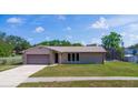 Inviting single-story home with attached garage, manicured lawn, and screened pool in the backyard at 1420 Felton St, Deltona, FL 32725
