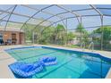 Relaxing screened-in pool area with clear blue water and lounge floats, perfect for outdoor enjoyment at 1420 Felton St, Deltona, FL 32725