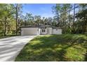 Single-story home featuring modern architecture, a two-car garage, and pristine landscaping at 1445 Enterprise Osteen Rd, Deltona, FL 32725