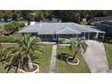 Aerial view of charming home with green paint, decorative shutters, mature landscaping, and spacious front yard at 1590 N Page Dr, Deltona, FL 32725