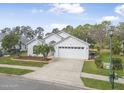 Charming single-story home with a well-manicured lawn, palm tree, and attached two-car garage at 232 Gala Cir, Daytona Beach, FL 32124