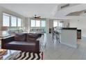 Bright, open-concept living room with tile floors, stylish furnishings, and views of the water at 241 Riverside Dr # 1502, Daytona Beach, FL 32117