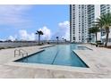 Outdoor swimming pool with lounge chairs, set with a view of the building and the city skyline at 241 Riverside Dr # 1502, Daytona Beach, FL 32117