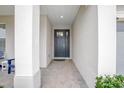 Covered entryway with brick flooring leading to a stylish front door, providing shelter and curb appeal at 291 Northcote Ct, Deland, FL 32724