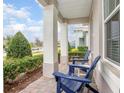 Inviting front porch with brick flooring and comfortable blue chairs, perfect for relaxing outdoors at 291 Northcote Ct, Deland, FL 32724