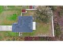 Aerial view of a house with solar panels, a fenced yard, and surrounding greenery showing the property's boundaries at 3318 Dewberry Dr, Deltona, FL 32738