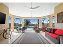 Enclosed patio with stylish seating, ceiling fans, and views of the pool and lush backyard at 3432 Wise Way, The Villages, FL 32163