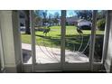 Screened in patio doors with heron design lead to a manicured yard and neighboring houses at 36320 Piney Ridge Blvd, Fruitland Park, FL 34731