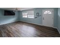 Bright living room featuring modern wood-look flooring, ceiling fan, and a large window at 412 Cherry St, South Daytona, FL 32119