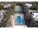 Expansive aerial view showcasing the community pool, tennis court, and lush landscaping throughout the neighborhood at 4150 S Atlantic Ave # 104 B, New Smyrna Beach, FL 32169