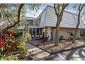 Inviting home exterior with a small front porch with chairs and a balcony overhead, complemented by lush landscaping at 4150 S Atlantic Ave # 104 B, New Smyrna Beach, FL 32169