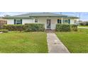 Charming single story home with a neatly maintained lawn and mature hedges at 445 Virginia Ave, St Cloud, FL 34769