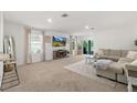 Bright living room features neutral tones, plush carpeting, and a sliding glass door to the outdoor space at 515 Stowers Dr, New Smyrna Beach, FL 32168