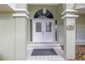 Elegant front entryway featuring double doors, decorative glass, and tiled steps at 5981 Jandon Ct, Port Orange, FL 32127
