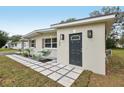 Inviting front entrance with a gray door and well-designed landscaping with stone pavers at 722 Valencia Ave, Orange City, FL 32763