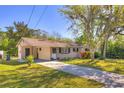Inviting single-story home with lush green lawn, mature trees, and a long driveway at 741 Greenway Pl, Daytona Beach, FL 32114