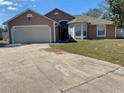 Charming single-story home featuring a two-car garage, neutral paint, and a well-maintained front yard at 7879 Camlyn Ct, Orlando, FL 32818