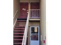 Exterior of a condo building featuring multiple doors and staircases leading to upper-level units at 1000 Lake Of The Woods Blvd # 104F, Casselberry, FL 32730