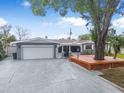 Charming single Gathering home with a two-car garage, and mature tree with deck in daytime at 1259 Vanderbilt Dr, Ormond Beach, FL 32174