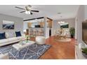 Open-concept living room with modern decor, tile floors, and seamless flow to the dining area and kitchen at 129 S Marydell Ave, Deland, FL 32720