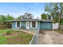 Charming teal single-story home with white trim, fenced yard and paved walkway at 1702 Carolina Ave, Ormond Beach, FL 32174