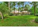 Beautiful one-story home featuring a sprawling green lawn, mature trees, and lush greenery at 1875 Glenwood Oaks Ln, Deland, FL 32720