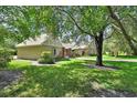 Side view of home with a detached garage and beautifully landscaped yard with large trees at 238 Crooked Tree Trl, Deland, FL 32724