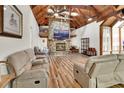 Spacious living room featuring a stone fireplace, high ceilings, and wood floors at 238 Crooked Tree Trl, Deland, FL 32724