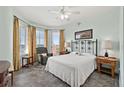 Charming bedroom with neutral walls, ceiling fan and view of the ocean from the balcony at 2515 S Atlantic Ave # 401, Daytona Beach Shores, FL 32118