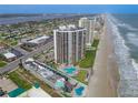 Scenic aerial view of beachfront condos with pools and direct beach access along the coastline at 2555 S Atlantic Ave # 1007, Daytona Beach Shores, FL 32118