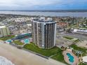 Aerial view of a high-rise condo by the ocean, with pools and city views in the background at 2555 S Atlantic Ave # 1007, Daytona Beach Shores, FL 32118