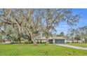 Inviting single-story home with mature shade trees, green lawn, and attached two-car garage at 2557 Shiprock Ct, Deltona, FL 32738