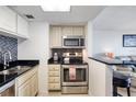 Well-equipped kitchen with stainless steel appliances, dark countertops and bar stool seating at 2700 Ocean Shore Blvd # 305, Ormond Beach, FL 32176