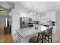 Bright kitchen featuring stainless steel appliances, a marble island, and modern lighting at 2859 Doe Run Trl, Orange City, FL 32763