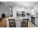 Spacious kitchen featuring stainless steel appliances, white cabinets, and marble island at 2859 Doe Run Trl, Orange City, FL 32763