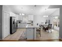 Airy kitchen with stainless steel appliances, white cabinets, and an island with marble countertop at 2859 Doe Run Trl, Orange City, FL 32763