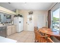 The kitchen features tile floors, stainless steel appliances and a white refrigerator at 3057 Norlina St, Deltona, FL 32738