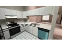 Bright kitchen with stainless steel appliances, white cabinets, and a contrasting black and white tile floor at 3550 Forest Branch Dr # A, Port Orange, FL 32129