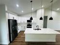 Bright modern kitchen showcasing stainless steel appliances, ample counter space, and stylish pendant lighting at 679 Rhodes Dr, Deland, FL 32720