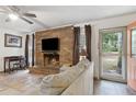 Cozy living room featuring a brick fireplace and access to a screened in porch at 749 Cassadaga Rd, Lake Helen, FL 32744