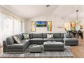 Bright living room features vaulted ceilings, a large sectional, and plenty of natural light from the large windows at 755 Fairlawn Dr, Orange City, FL 32763