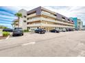 Exterior of the condo building with multiple cars parked in the parking lot on a sunny day at 935 Ocean Shore Blvd # 4010, Ormond Beach, FL 32176