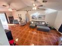 Cozy living room featuring vaulted ceiling, ceiling fans, and a large comfortable sectional sofa at 1031 Tony Cir, St Cloud, FL 34772