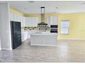 Bright kitchen featuring an island, stainless steel appliances, and an open concept layout at 1077 Chelan Falls N Trl, Deland, FL 32724
