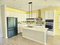 Bright kitchen with white cabinets, stainless steel appliances, center island, and decorative backsplash at 1077 Chelan Falls N Trl, Deland, FL 32724