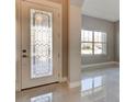 Bright foyer showcasing tile floors, a decorative door, and view into another room at 1204 Draycott St, Ormond Beach, FL 32174
