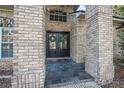 Close-up of the double front doors with brick pillars and a slate tile entryway at 1500 Wyngate Dr, Deland, FL 32724