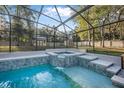 Relaxing screened pool with a built-in hot tub and waterfall feature at 1500 Wyngate Dr, Deland, FL 32724