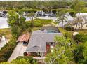 Aerial view of home featuring a screened pool, carport, and picturesque lake backdrop at 1957 Monterey Dr, Deltona, FL 32738